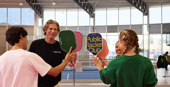 Players exchanging paddles on an indoor court