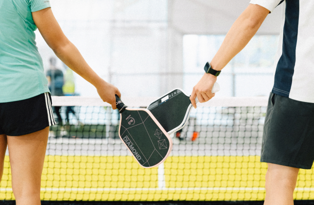 Two players tap paddles over the net