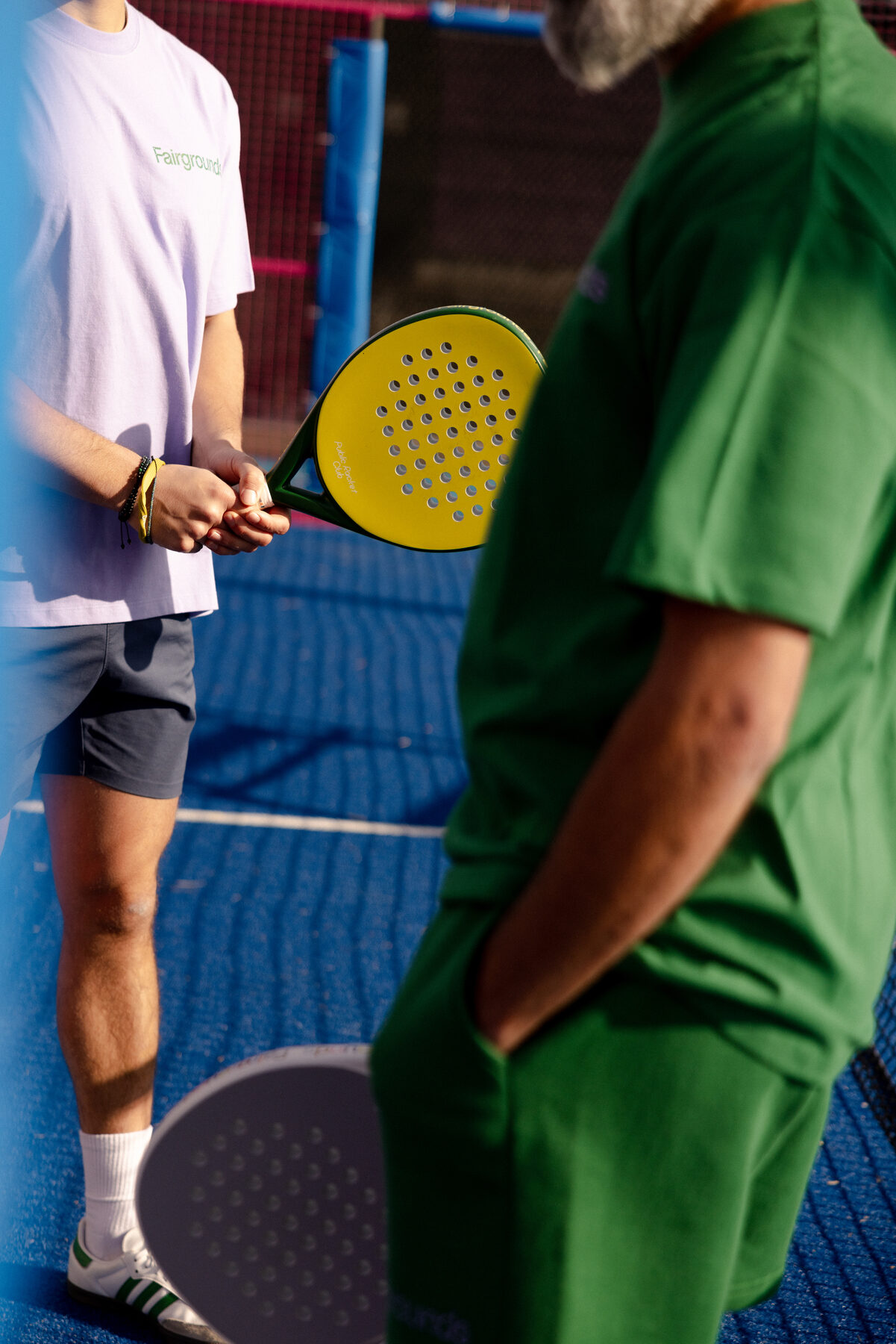 A coach working with a player, paddle in hand